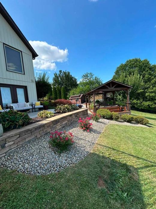 Backyard patio and stone wall landscaping after service