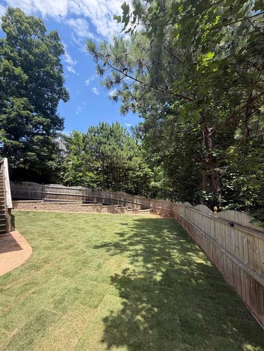 Backyard lawn with retaining wall and privacy fence